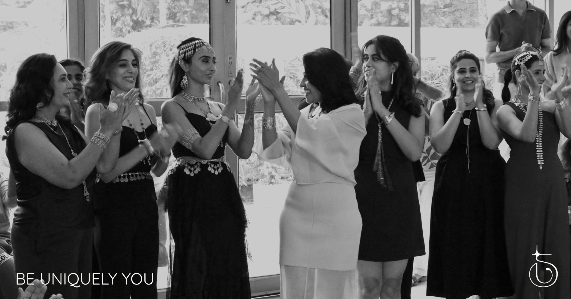 Women wearing Thingalicious jewelry line up and applaud together, with the line "Be Uniquely You" in the corner.